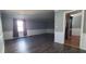 Spacious living room featuring gray walls, white trim, wood-look floors, and natural light at 3230 Meadowcrest Dr, Anderson, IN 46011