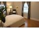 Stylish bedroom with a comfortable bed, striped curtains, and a plush chair, accentuated by natural light at 1185 N 10Th St, Noblesville, IN 46060