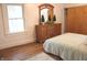 Cozy bedroom with a wooden dresser, mirror, and natural light, showcasing a relaxing space at 1185 N 10Th St, Noblesville, IN 46060