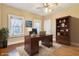 Inviting home office with a large desk, bookshelf, and natural light from the windows at 1185 N 10Th St, Noblesville, IN 46060