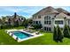 A gorgeous backyard view featuring a swimming pool, lounge chairs and elegant architecture on a sunny day at 11492 Hanbury Manor Blvd, Noblesville, IN 46060