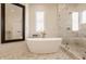 Luxurious bathroom featuring a soaking tub, a glass enclosed shower, and marble-like walls at 11492 Hanbury Manor Blvd, Noblesville, IN 46060