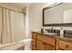 Bathroom featuring a bathtub and shower with a glass door, alongside a vanity with dark countertops and a mirror at 11492 Hanbury Manor Blvd, Noblesville, IN 46060