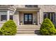 Elegant stone entrance with a dark double door and manicured greenery, enhancing curb appeal at 11492 Hanbury Manor Blvd, Noblesville, IN 46060
