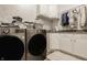 Laundry room with front loading machines, white cabinets and decorative wallpaper at 11492 Hanbury Manor Blvd, Noblesville, IN 46060