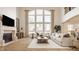 Bright living room boasts a fireplace, hardwood floors, and large windows offering natural light at 11492 Hanbury Manor Blvd, Noblesville, IN 46060