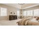 Bright main bedroom featuring tray ceilings, neutral walls, large windows, and cozy sitting area at 11492 Hanbury Manor Blvd, Noblesville, IN 46060