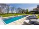 A modern pool with lounge chairs on the patio with mature trees adding privacy to the outdoor space at 11492 Hanbury Manor Blvd, Noblesville, IN 46060