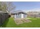 View of backyard with garden beds, a well-kept lawn, and a charming outbuilding at 2819 Mars Hill St, Indianapolis, IN 46241