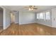 Living room with wood-look floors, a ceiling fan, neutral gray paint, and a window at 2819 Mars Hill St, Indianapolis, IN 46241