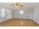 Well-lit living room with wood-look floors, neutral paint, and a classic ceiling fan at 2819 Mars Hill St, Indianapolis, IN 46241