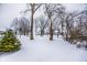 View of a snowy yard with leafless trees and a glimpse of houses at 10555 E 400 S, Zionsville, IN 46077