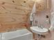 Cozy bathroom with a tub and sink area, featuring wood walls, a mirror, and a window for natural light at 6486 Coyote Dr, Nineveh, IN 46164