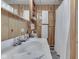 The bathroom showcases wood paneling, a sink, and storage shelves with fresh white towels for a cozy cabin feel at 6486 Coyote Dr, Nineveh, IN 46164