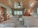 Spacious bedroom with a wood ceiling, three twin beds, side tables, and a connecting bathroom with a toilet and shower at 6486 Coyote Dr, Nineveh, IN 46164