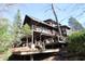 Stunning view of the wooden house with its multiple decks, nestled in a hillside setting with surrounding trees at 6486 Coyote Dr, Nineveh, IN 46164