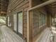 A close-up of the house's wooden exterior, highlighting the deck, windows, and door with glass panels at 6486 Coyote Dr, Nineveh, IN 46164