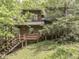 A charming log cabin home features a cozy porch and a set of wooden stairs leading to the entrance at 6486 Coyote Dr, Nineveh, IN 46164
