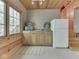 Charming kitchenette featuring a sink, appliances, wood cabinets, a window, and wood-paneled walls and ceiling at 6486 Coyote Dr, Nineveh, IN 46164