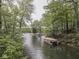 Picturesque view of lake with covered boat and dock surrounded by lush green trees at 6486 Coyote Dr, Nineveh, IN 46164