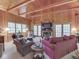 Comfortable living room with wood-paneled walls, fireplace, large windows, and cozy seating at 6486 Coyote Dr, Nineveh, IN 46164