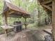 Outdoor cooking area with metal roof cover featuring a grill, prep area and wooded views at 6486 Coyote Dr, Nineveh, IN 46164