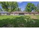 The back of a brick house with a large, grassy yard and mature trees at 2925 Highwoods Dr, Indianapolis, IN 46222