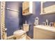 A well-lit full bathroom with a white sink, toilet, vanity, medicine cabinet, and blue walls at 2925 Highwoods Dr, Indianapolis, IN 46222