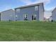 View of home's siding, grassy backyard, and sliding glass doors for easy outdoor living at 7108 Parkstay Ct, Indianapolis, IN 46113