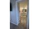 Bathroom features double vanity with white cabinets, gray wood-look floor and well-lit mirrors at 7108 Parkstay Ct, Indianapolis, IN 46113