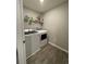 Bright laundry room features modern washer and dryer, shelving and gray wood-look floors at 7108 Parkstay Ct, Indianapolis, IN 46113