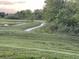 View of a paved walking path winding through a grassy park with pond and mature trees at 7108 Parkstay Ct, Indianapolis, IN 46113