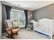 Cozy Bedroom featuring rocking chair, crib, and gray walls at 778 Kingston Cir, Brownsburg, IN 46112