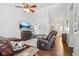 Inviting living room featuring a ceiling fan, hardwood floors, and comfortable leather seating at 778 Kingston Cir, Brownsburg, IN 46112