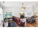 Living room featuring hardwood floors, a ceiling fan, leather sofas, and two entertainment centers at 778 Kingston Cir, Brownsburg, IN 46112