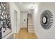 Bright foyer with modern light fixture, white walls, and open staircase with light wood treads at 527 E North St, Indianapolis, IN 46204