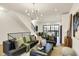 Bright living room featuring a modern chandelier, neutral paint, hardwood flooring, and staircase at 527 E North St, Indianapolis, IN 46204