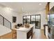 Modern kitchen with an island, a staircase with black railings, and an open floor plan at 531 E North St, Indianapolis, IN 46204