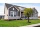 Gray farmhouse exterior with white trim, stone accents, and a landscaped lawn at 11362 Selsey Rd, Fishers, IN 46040