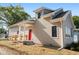 Tan house with red door, landscaping, and ramp at 1320 Pearl St, Columbus, IN 47201