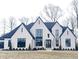 Stunning two-story home with white brick and black accents at 10876 Holliday Farms Blvd, Zionsville, IN 46077