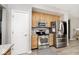 Galley kitchen featuring stainless steel appliances and natural wood cabinets at 19140 Golden Meadow Way, Noblesville, IN 46060