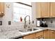 Well-lit kitchen with a stainless steel sink, granite countertops, and natural wood cabinets at 19140 Golden Meadow Way, Noblesville, IN 46060