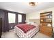 Comfortable bedroom with a plaid blanket, two windows with dark curtains and neutral walls at 605 Brentwood E Dr, Plainfield, IN 46168