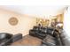 Spacious living room with hardwood floors featuring an oversized sectional sofa with views into the kitchen area at 605 Brentwood E Dr, Plainfield, IN 46168