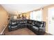 Open-concept living room with hardwood floors and a large sectional sofa, seamlessly connected to the kitchen at 605 Brentwood E Dr, Plainfield, IN 46168