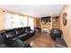 Inviting living room featuring a fireplace, a large TV, and an oversized, plush black leather sectional sofa at 605 Brentwood E Dr, Plainfield, IN 46168