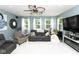 Comfortable living room with a modern ceiling fan, cozy furniture, and large windows for natural light at 605 Brentwood E Dr, Plainfield, IN 46168