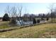 Scenic pond surrounded by trees, with the home and outbuildings barely visible in the background at 13205 E Legal Tender Rd, Columbus, IN 47203