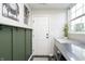 Laundry room with green accent wall and built-in storage at 10561 Sand Creek Blvd, Fishers, IN 46037